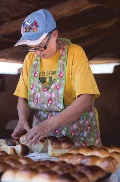  ??  ?? Elvira Valencia prepares horno bread from her family recipe Sunday at La Fiesta de Nuestra Señora de los Ángeles following Mass at the annual.