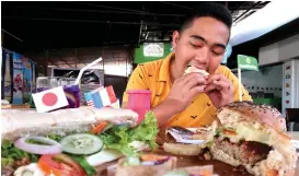  ??  ?? Husband is enjoying his food. He dislikes veggies but he ate up this burger stuffed with sooo many lettuce, tomatoes, and onions.