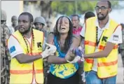  ?? Dai Kurokawa
European Pressphoto Agency ?? RESCUERS USHER a woman out of a building where she was held hostage. A siege by Somali gunmen in Garissa, Kenya, left 147 students dead.
