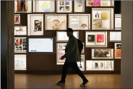  ?? SUE OGROCKI — THE ASSOCIATED PRESS ?? A man walks past a portion of the archive wall at the Bob Dylan Center in Tulsa, Okla. A report released Tuesday offers a comprehens­ive look at American philanthro­py.