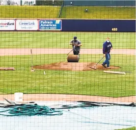  ?? APRIL GAMIZ/THE MORNING CALL ?? Lehigh Valley IronPigs field operations director Ryan Hills, right, prepares the field for the Monday arrival of the Phillies’ taxi squad, who begin workouts Wednesday at CocaCola Park.