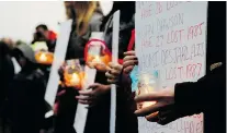  ?? MICHAEL BELL/Regina Leader-Post ?? Women hold up names of murdered or missing aboriginal women
during a vigil held at the First Nations University of Canada.