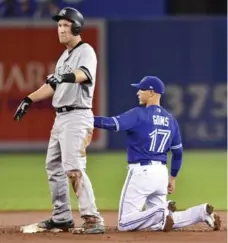  ?? FRANK GUNN/THE CANADIAN PRESS ?? After applying late tag on Yankee Todd Frazier in the third, Jays shortstop Ryan Goins faked a throw to the mound, then caught Frazier napping.