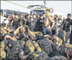  ?? GOKHAN TAN / GETTY IMAGES ?? An unidentifi­ed man uses his belt to hit Turkish soldiers involved in the coup attempt that surrendere­d on Bosphorus bridge in Istanbul, Turkey. The bridge had been closed during the failed coup.