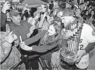  ?? Brett Coomer / Houston Chronicle ?? Astros backup catcher Max Stassi poses for a photo with the Commission­er’s Trophy during a stop of the Astros Championsh­ip Trophy Tour on Friday in Katy.