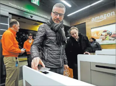  ?? Elaine Thompson The Associated Press file ?? A customer scans his cellphone app at the Amazon Go store in Seattle in 2018. Shoppers scan their smartphone at a turnstile, pick out items and leave. “People are like, ‘Oh, I like this,’ ” said Val Vacante, director of strategy at Livearea.