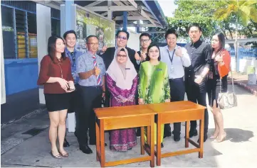  ??  ?? Don (back row, fifth right) and his Boulevard Miri team join Jetai (front, fourth left) and other school staff in a photo-call after the presentati­on of the new desks at SK St Columba.