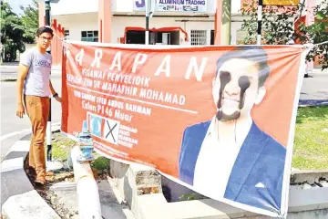  ??  ?? Pribumi Muar candidate Syed Saddiq with one of his vandalised banners.