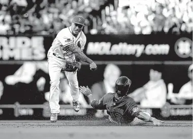  ?? Associated Press ?? Chicago Cubs’ Starlin Castro is forced out at second as St. Louis Cardinals second baseman Kolten Wong throws to first during the second inning of Game 2 of the National League Division Series on Saturday in St. Louis. Austin Jackson was safe at first...