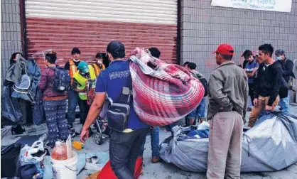  ?? Agence France-presse ?? HARD TIMES: Migrants travelling in the Central American caravan hoping to reach the United States are being relocated in a warehouse to be used by migrants who were sleeping in the streets as a temporary shelter, in Tijuana, Baja California State, Mexico. A seven-year-old Guatemalan girl died of dehydratio­n and exhaustion in the custody of US border agents last week as President Donald Trump struggles to deter a tide of migrants fleeing poverty and violence in Central America — and battles with Congress for a budget to build a massive wall across much of the Us-mexico frontier.