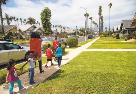  ?? Photograph­s by GINA FERAZZI LOS ANGELES TIMES ?? SANDRA PRUITT leads the kids she babysits to a park near her Jefferson Park home. She worries that her neighborho­od will change.