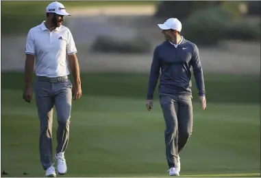  ?? KAMRAN JEBREILI — THE ASSOCIATED PRESS ?? Dustin Johnson and Rory McIlroy talk on the 10th fairway during the first round of the 2018Abu Dhabi Championsh­ip.