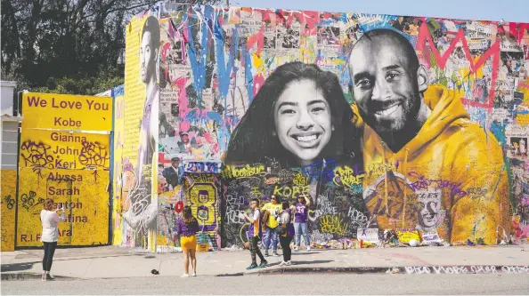  ?? KYLE GRILLOT / REUTERS FILES ?? Fans gather around a mural of NBA great Kobe Bryant and his daughter Gianna Bryant at a public memorial at the Staples Center in Los Angeles.