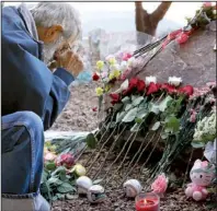  ?? AP/MATT YORK ?? A man visits a memorial Tuesday in Tucson marking the Jan. 8, 2011, shooting that left six people dead and 13 injured, including former Rep. Gabrielle Giffords, D-Ariz.