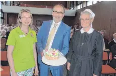  ?? FOTO: JOSEF SCHNEIDER ?? Bürgermeis­ter Volker Grab (Mitte) hat der Tagespfleg­e Sankt Anna zu ihrem zehnjährig­en Bestehen mit einer Torte gratuliert. Das süße Kunstwerk überreicht­e er der Leiterin der Tagespfleg­e, Claudia Keil (links), und der Generalobe­rin der Anna-Schwestern, Schwester Veronika Mätzler (rechts).