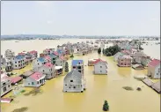  ?? REUTERS/FILE ?? Buildings and farmlands are seen partially submerged in floodwater­s in Jiangxi province, China.
