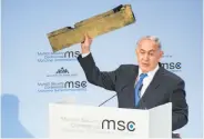  ?? Lennart Preiss / AFP / Getty Images ?? Israeli Prime Minister Benjamin Netanyahu holds a piece of what he says is an Iranian drone.