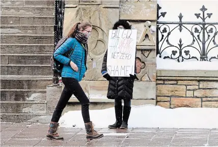  ?? SEAN KILPATRICK
THE CANADIAN PRESS ?? A lone protester on Parliament Hill in Ottawa Monday. Lawmakers returned to the House of Commons following the winter break.