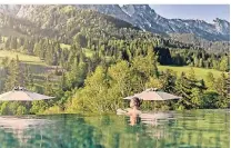  ?? FOTO: HOTEL FORSTHOFGU­T ?? Im Hotel „Forstgutho­f“in Österreich können Gäste vom Pool aus die Aussicht auf Berge und Bäume genießen.