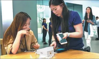  ?? AFP ?? A woman buys an iPhone 8 Plus at an Apple showroom in Shanghai on Friday. The Apple iPhone 8 and 8 Plus have gone for sale in China starting Friday.