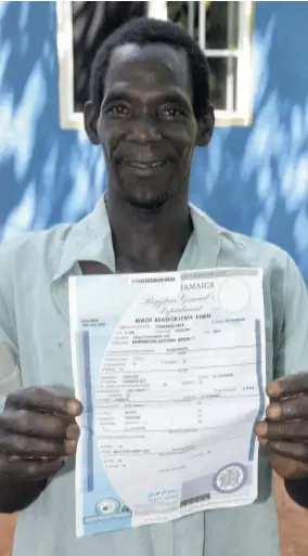  ??  ?? Barrington Angus shows off a copy of his birth certficate which he was able to receive from the Registrar General’s Department after he disclosed that he did not have one the last time the Jamaica
Observer visited his home.