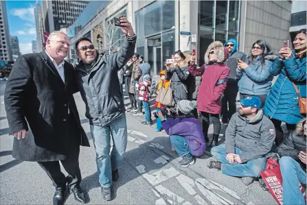 ?? RICK MADONIK TORONTO STAR ?? Newly minted Ontario PC Leader Doug Ford, in Toronto’s St. Patricks Day Parade, stops for a selfie with Mitch Cabrias on Bloor Street West.