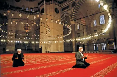  ?? Picture: Reuters ?? Staff at Suleymaniy­e Mosque perform a morning prayer behind closed doors during the first day of Eid and the second day of a four-day curfew, amid the Covid-19 outbreak, in Istanbul, Turkey, yesterday.