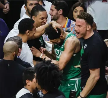  ?? MEGAN BRIGGS — GETTY IMAGES ?? Derrick White, center, is mobbed by his Celtics teammates after Saturday's thrilling Game 6win over the Heat in Miami.