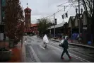  ?? Fallon/AFP/Getty Images ?? A person covered with a blanket walks past an encampment near Union Station in Portland in January. Photograph: Patrick T