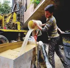  ?? AP ?? ■ A worker clears the mud from a drill as a water well is put in at a luxury apartment complex in the Campo Alegre neighbourh­ood of Caracas.