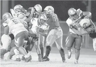  ?? ?? Coconut Creek Cougars running back Brian Skipper tries to squeeze through the Western Wildcats defense during the second half of their game Friday.