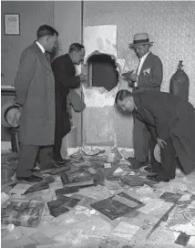  ?? ?? Anthony Dodero, from left, Thomas Moore, Lou Moulds and Herbert Carlin, leaning over, examine the hole made by five thieves who stole $7,102 from Guyon’s Paradise Ballroom on Chicago’s West Side on April 8, 1929. Two of the robbers had been at the last dance of the night and forced a night porter to let in their three accomplice­s. The porter then sat under guard as the robbers “hammered a hole in the brick vault with chisels,” reported the Tribune on April 9, 1929. It took them four hours.