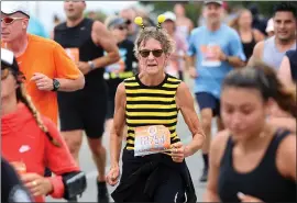  ?? ?? A bumble bee runs along East Cliff Drive on Sunday at the 50th annual Wharf to Wharf race. The race brings out numerous costumes and creative participat­ion by community members as well as stellar athletic pursuit by elite runners.