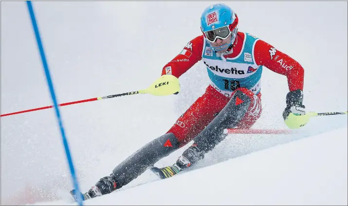  ?? — THE ASSOCIATED PRESS ?? Stefano Gross of Italy clears a gate during the first run of the World Cup men’s slalom race in Adelboden, Switzerlan­d, on Sunday. Gross won the event.