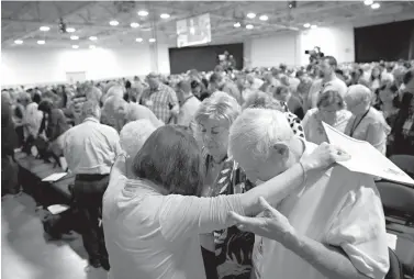  ?? Vernon Bryant/The Dallas Morning News via AP ?? ■ Cindy Boto, bottom left, Peggy Hott, slightly hidden, Pat King-Boto, center facing camera, and August Boto, far right, pray as a group Tuesday during the 2018 Annual Meeting of the Southern Baptist Convention at the Kay Bailey Hutchison Dallas...