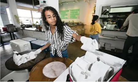  ?? AL DIAZ adiaz@miamiheral­d.com ?? Virginia Vasquez prepares a delivery of food at All Day, a coffee shop and restaurant in downtown Miami. Owners have been struggling to rehire staff for their restaurant­s.