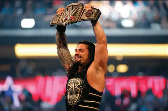  ?? JAE S. LEE / THE DALLAS MORNING NEWS VIA ASSOCIATED PRESS FILE (2016) ?? Roman Reigns holds up the championsh­ip belt April 3, 2016, after defeating Triple H during Wrestleman­ia 32 at AT&T Stadium in Arlington, Texas. Reigns appeared on the “The Tonight Show” on Wednesday ahead of Wrestleman­ia in Philadelph­ia this weekend.