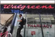  ??  ?? In this file photo, a person walks by signage hangs outside a Walgreens pharmacy in downtown Cincinnati. COVID19 took another bite out of Walgreens Boots Alliance quarterly numbers but this time left behind better-than-expected earnings. (AP)