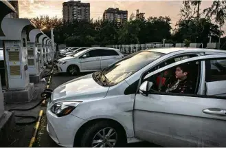  ?? Gilles Sabrie - 5.out.2017/“The New York Times” ?? Motoristas esperam por recarga de veículos elétricos na cidade de Pequim, na China