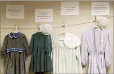  ?? AP file photo ?? Dresses donated by sexual assault survivors from Amish and other plain-dressing religious groups hang on a clotheslin­e beneath a descriptio­n of each survivors’ age and church affiliatio­n, on April 29, in Leola, Pa. The exhibit’s purpose was to show that sexual assault is a reality among children and adults in such groups. Similar exhibits held nationwide aim to shatter the myth that abuse is caused by a victim’s clothing choice.