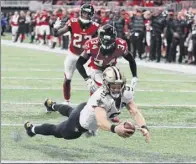  ?? Curtis Compton / Atlanta Journal-constituti­on via AP ?? New Orleans QB Drew Brees dives into the end zone past Atlanta’s Brian Poole and Robert Alford to tie their game 37-37 and send it to overtime. The Saints went on to win on another Brees keeper.