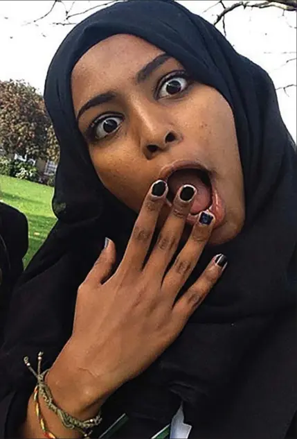  ??  ?? Painted nails: Fifteen-year-old Amira Abase larks around with her friends in the park