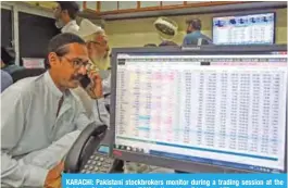  ?? — AFP ?? KARACHI: Pakistani stockbroke­rs monitor during a trading session at the Pakistan Stock Exchange (PSX) in Karachi on Friday.