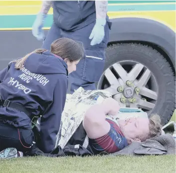  ??  ?? Scarboroug­h RUFC’s Benny Blackall is attended to on the pitch by physio Breesha Curphey after his horrific injury