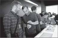  ?? BLOOMBERG/DAVID PAUL MORRIS ?? Personal trainer Robert “Bob” Harper, left, tries on the Apple Watch during the Apple Inc. Spring Forward event in San Francisco, California, U.S., last week.