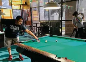  ??  ?? John Reyes and Nina Estrada are back to playing pool at Slick Willie's Family Pool Hall. “But we only stay here for two or three hours, tops,” she says.