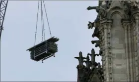  ?? CHRISTOPHE ENA — THE ASSOCIATED PRESS ?? A crane hoists scaffoldin­g past gargoyles Thursday outside the Notre Dame Cathedral in Paris. Nearly $1 billion has already poured in from ordinary worshipper­s and high-powered magnates around the world to restore Notre Dame Cathedral in Paris after a massive fire.