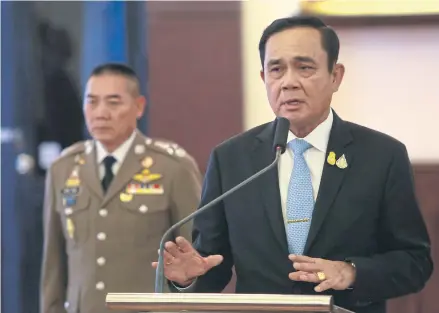  ?? SOMCHAI POOMLARD ?? Prime Minister and Defence Minister Prayut Chan-o-cha speaks at the Royal Thai Police headquarte­rs on Friday. He has announced he would oversee the force to drive police reform.