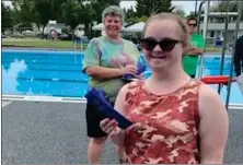  ?? ?? Swift Current swimmer Tamara Gleim pictured during the ribbon presentati­on at the Swift Current Special Olympics swim meet, June 19. Swim coach Jackie Powell is standing in the background.