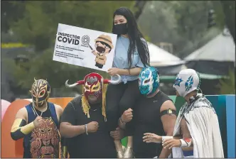  ??  ?? Lucha Libre fighters pose for a photo during a campaign to promote the use of masks during the covid 19 pandemic in Xochimilco.